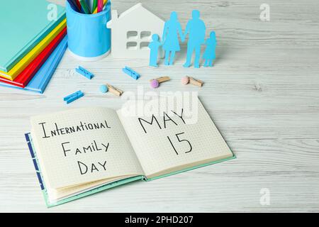 Alles Gute Zum Familientag. Komposition mit Notizbuch und Schreibwaren auf weißem Holztisch Stockfoto