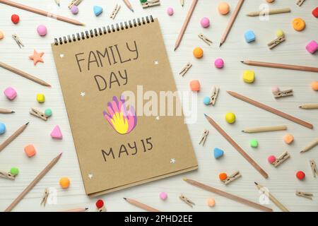 Alles Gute Zum Familientag. Flache Verlegung mit Notizbuch und Schreibwaren auf weißem Holztisch Stockfoto