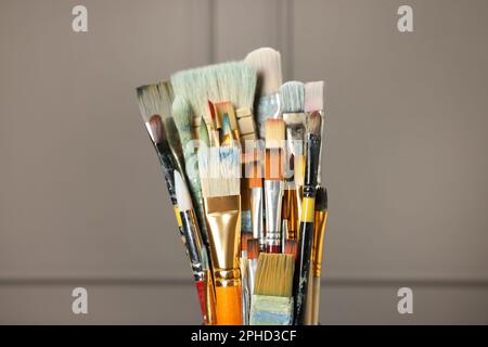 Satz verschiedener Pinsel auf grauem Hintergrund, Nahaufnahme Stockfoto