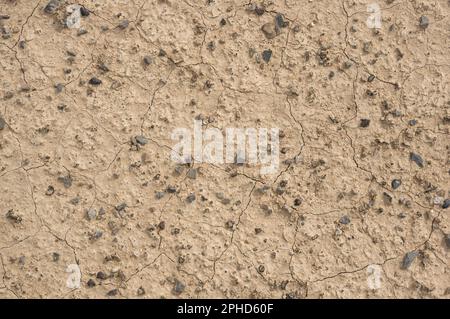 Trockener brauner Wüstenboden mit Rissen und Kieseln Stockfoto