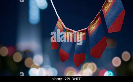Eine Girlande mongolischer Nationalflaggen auf abstraktem, verschwommenem Hintergrund. Stockfoto