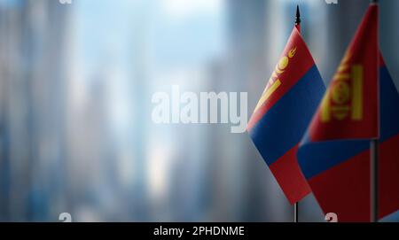 Kleine Flaggen der Mongolei auf abstraktem, verschwommenem Hintergrund. Stockfoto