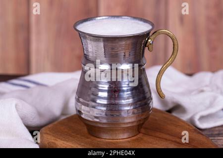 Buttermilch. Schäumende Buttermilch in einem Eisenglas. Mit Joghurt und Wasser zubereitetes Getränk. Traditionelle türkische Köstlichkeiten. Lokaler Name Ayran Stockfoto