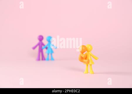 MYKOLAIV, UKRAINE - 04. JANUAR 2022: Bunte menschliche Figuren auf pinkfarbenem Hintergrund. Leihmutterschaftskonzept Stockfoto