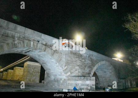 Regensburg, Deutschland. 28. März 2023. Ein Minibus ist durch das Geländer der „Steinbrücke“ gebrochen. Laut Polizei ragte der vordere Teil des Wagens in Richtung Abgrund. Ein Mann hatte zuvor den Minibus auf die Brücke gefahren, was gegen das Verbot verstieß, und ist gegen die Steinbarriere gestürzt. Er konnte sich vom Auto befreien und floh vom Unfallort. (Zu dpa 'Minibus durchbricht Brücken in Regensburg') Kredit: Tiedemann/vifogra/dpa/Alamy Live News Stockfoto
