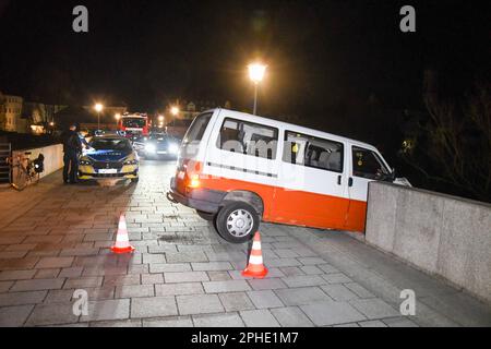 Regensburg, Deutschland. 28. März 2023. Ein Minibus ist durch das Geländer der „Steinbrücke“ gebrochen. Laut Polizei ragte der vordere Teil des Wagens in Richtung Abgrund. Ein Mann hatte zuvor den Minibus auf die Brücke gefahren, was gegen das Verbot verstieß, und ist gegen die Steinbarriere gestürzt. Er konnte sich vom Auto befreien und floh vom Unfallort. (Zu dpa 'Minibus durchbricht Brücken in Regensburg') Kredit: Tiedemann/vifogra/dpa/Alamy Live News Stockfoto