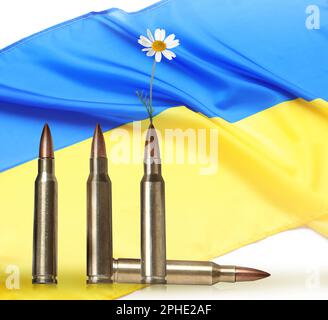 Wunderschöne blühende Blume, Kugeln und ukrainische Nationalflagge auf weißem Hintergrund. Frieden statt Krieg Stockfoto