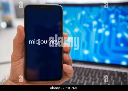 Midjourney Logo des neuronalen Netzwerks auf dem Bildschirm des Smartphones in der hand und Laptop mit Neuronet auf dem Splash-Bildschirm im Hintergrund. Künstliche Intelligenz Konzept, März 2023, Prag, Tschechische Republik. Stockfoto