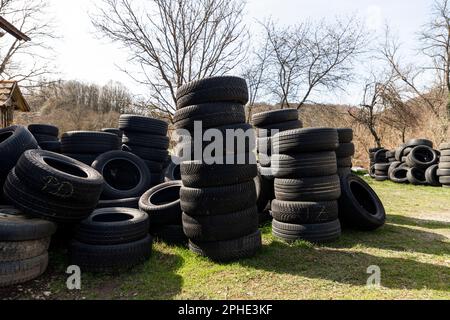 Ein Haufen Autoreifen im Hinterhof des Hauses an einem sonnigen Tag Stockfoto