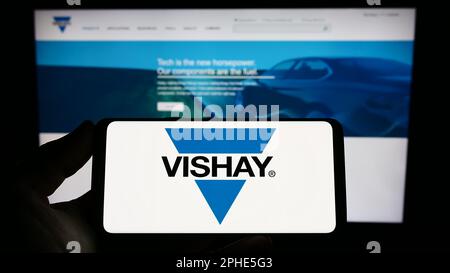 Person, die ein Smartphone mit dem Logo des US-Unternehmens Vishay Intertech Inc. Auf dem Bildschirm vor der Website hält. Konzentrieren Sie sich auf das Display des Telefons. Stockfoto