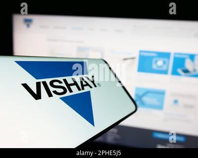 Mobiltelefon mit Logo der amerikanischen Firma Vishay Intertech Inc. Auf dem Bildschirm vor der Website. Fokus auf die Mitte links des Telefondisplays. Stockfoto