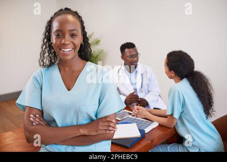 Porträt einer lächelnden Krankenschwester, die mit Kollegen im medizinischen Konferenzraum steht Stockfoto