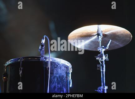 Professionelles Schlagzeug mit Mikrofon, das während der Musik auf der Bühne steht Anzeigen Stockfoto