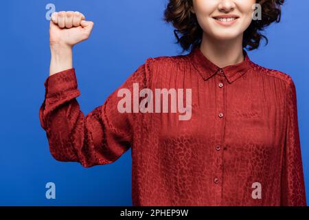 Zugeschnittene Ansicht eines Lächelpädagogen für Gebärdensprache mit isolierter Geste auf blauem Stockbild Stockfoto