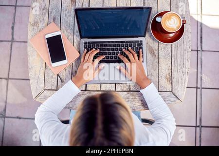 Hände, Laptop und Frau von oben mit Kaffee, freiberufliche Autorin tippt mit Online-Fernarbeit im Café. Freiberufler, Blogger oder Content-Ersteller Stockfoto