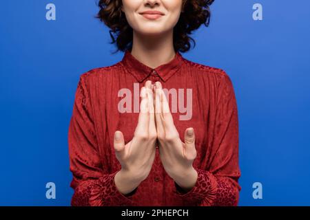 Teilansicht einer glücklichen Frau, die in Gebärdensprache spricht, isoliert auf blauem Stockbild Stockfoto