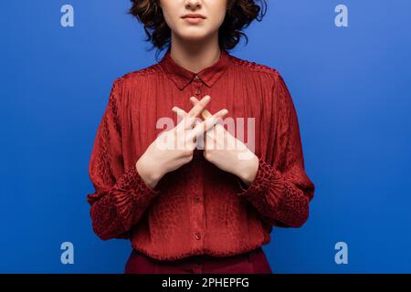 Zugeschnittene Ansicht eines jungen Lehrers, der Gesten mit Gebärdensprache verwendet, isoliert auf blauem Stockbild Stockfoto