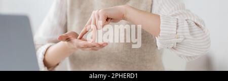 Zugeschnittene Ansicht einer Frau, die Standwort zeigt, während sie Zeichensprache, Banner, Stockbild lehrt Stockfoto