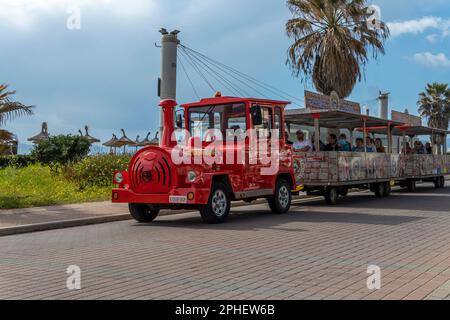 Playa de Palma, Spanien; märz 19 2023: Elektrischer Touristenzug mit Touristen an Bord, an einem sonnigen Tag an der Promenade von Palma de Mallorca. Spanien Stockfoto