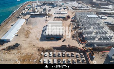 Vorgefertigte Industriegebäude auf der Baustelle. Betonfundamente und Metallrahmen von im Bau befindlichen Lagerhäusern Stockfoto