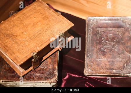 Nahaufnahme der alten Bücher in Lederbindung mit Kupferschlössern auf dem Tisch Stockfoto