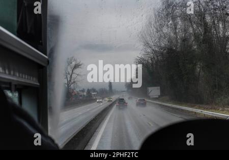 Blick hinter dem Busfahrer auf dem französischen Straßensystem in den Ausläufern der Alpen im Winter Stockfoto