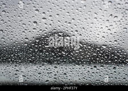 Regentropfen auf Autofenster Stockfoto