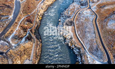 Der schnell fließende Fluss Skjalfandafljot, stromabwärts vom Wasserfall Godafoss. Drohne aus der Vogelperspektive im Herbst mit Schneegestreut Stockfoto
