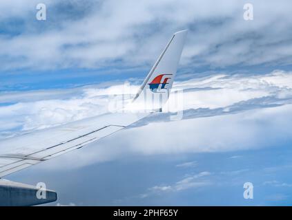 Kuala Lumpur, Malaysia - 22. Februar 2023: Flügel der malaysischen Fluggesellschaften im Flug. Malaysia Airlines ist die Flaggenfluggesellschaft Malaysias. Stockfoto