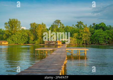 Pier an der Küste am Morgen in Saporkren Waisai, Raja Ampat, Häuser im Hintergrund über dem Wasser Stockfoto