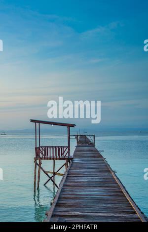 Pier am Morgen an der Küste des Dorfes Saporkren Waisai, Raja Ampat, blauer Himmel, vertikal Stockfoto