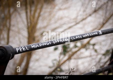 Manchester, Großbritannien. 26. März 2023. Grafitti mit Anti-Peel-Haltefunktion am Handlauf. Pomona Island, Trafford, Greater Manchester. Einst ein belebtes Hafengebiet und heute ein ruhiges urbanes Ödland. Es ist die Heimat vielfältiger Vögel, einschließlich Kestrels und Wasservögel, und vielfältiger Pflanzen. Pomona grenzt an Salford, Old Trafford und Manchester City Centre. Eine alternative Landschaft und ehemaliger Standort der Pomona-Gärten der Standort soll von der Peel Group Firma Peel L&P entwickelt werden Bild: Garyroberts/weltweites Erscheinungsbild. Kredit: GaryRobertsphotography/Alamy Live News Stockfoto