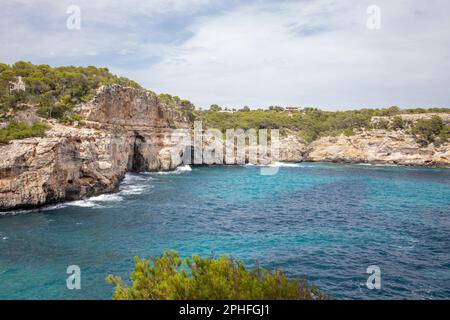 Dieser Luftblick auf eine zerklüftete Küste bietet felsige Klippen mit Blick auf ein wunderschönes blau-weißes Meer Stockfoto
