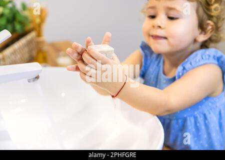 Das Kind wäscht seine Hände mit Seife. Selektiver Fokus. Kleiner. Stockfoto