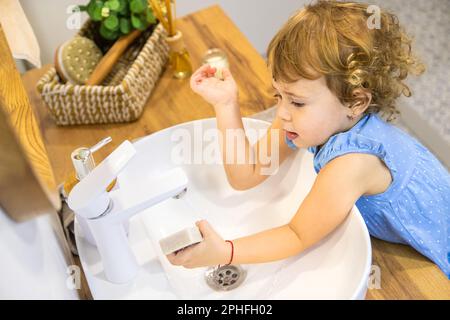 Das Kind wäscht seine Hände mit Seife. Selektiver Fokus. Kleiner. Stockfoto