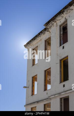 Ein Hochhaus mit zerbrochenen Fenstern, das von Tageslicht beleuchtet wird, Kristiansund, Norwegen Stockfoto