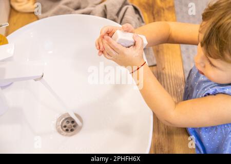 Das Kind wäscht seine Hände mit Seife. Selektiver Fokus. Kleiner. Stockfoto