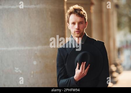 Porträt eines eleganten jungen Mannes in formeller, eleganter Kleidung, die draußen in der Stadt ist Stockfoto