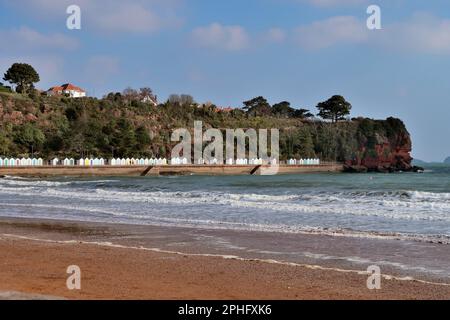 Ein Wintertag am Goodrington Sands, South Devon, mit Strandhütten am Fuße von Roundham Head. Stockfoto