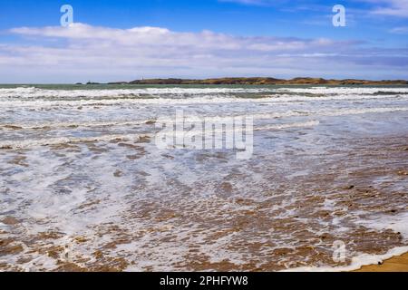 Bei Flut rollt die Welle zum Sandstrand von Newborough mit Blick auf Llanddwyn Island. Newborough, Isle of Anglesey, Wales, Vereinigtes Königreich, Europa Stockfoto