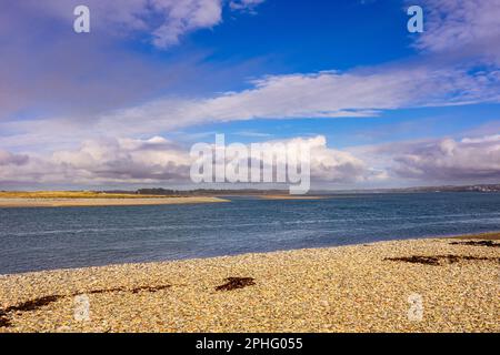 Blick vom Strand auf dem Festland zum Abermenai Point auf Anglesey über die Menai-Straße. Dinas Dinlle, Caernarfon, Gwynedd, Nordwales, Vereinigtes Königreich, Großbritannien Stockfoto