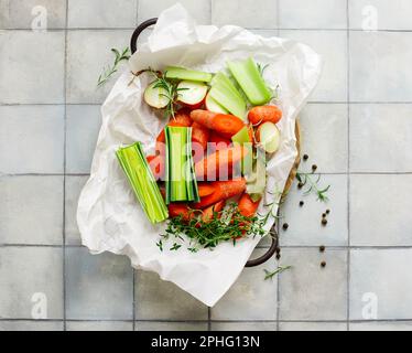 Frisches Gemüse und Kräuter für Bouillon im table.selective-Fokus Stockfoto