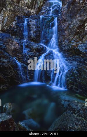 Schöner Wasserfall mit verschwommenem Wassereffekt. Foto im Tal der fünf Teiche in der polnischen Tatra. Foto mit langer Belichtung. Stockfoto