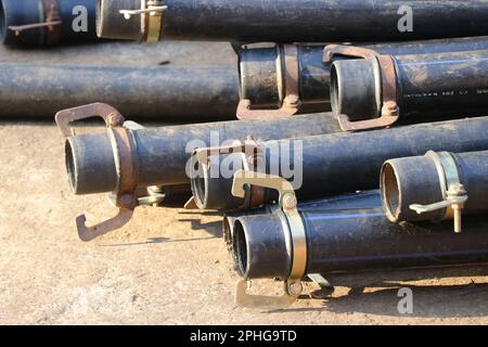 Gruppe von HDPE-Rohren mit Metallschellen für die Wasserversorgung Stockfoto
