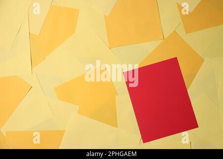 Eine rote Haftnotiz wird auf einem leuchtend gelben Hintergrund platziert, der aus mehreren gelben Haftnotizen besteht Stockfoto