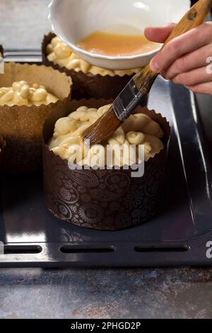 Der Süßstoff bereitet das Produkt zum Backen vor und schmiert das Ei mit dem Osterkuchen Stockfoto