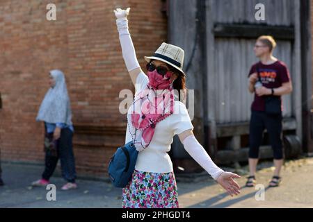 Chiang Mai, Chiang Mai, Thailand. 28. März 2023. Ein Tourist posiert für ein Foto am Tha Phae Gate in Chiang Mai, Thailand, wo die Luftqualität am Sonntag (26. März) mit einem Luftindex von 180 die schlechteste der Welt war. Am Dienstag (28. März), als dieses Foto aufgenommen wurde, war es 155. Die schlechte Luft wird zum Teil dadurch verursacht, dass die Landwirte während der Trockenzeit des Landes ihre Felder in Vorbereitung auf die in den letzten Jahren zunehmende Pflanzsaison verbrennen. (Kreditbild: © Brennan O'Connor/ZUMA Press Wire) NUR REDAKTIONELLE VERWENDUNG! Nicht für den kommerziellen GEBRAUCH! Stockfoto