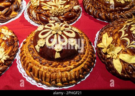 Traditionelles ukrainisches Hochzeitsbrot isoliert auf rotem Hintergrund. Rundes Laib-Hochzeitsbrot mit Blick von oben. Stockfoto