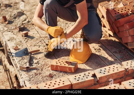 Nahaufnahme des Bauarbeiters in Uniform und Sicherheitsausrüstung bei der Vorbereitung auf die Arbeit Stockfoto