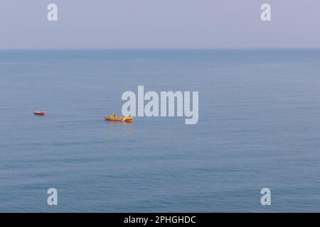 Ein Boot nähert sich der Küste von Murudeshwar (Karnataka, Indien) Stockfoto